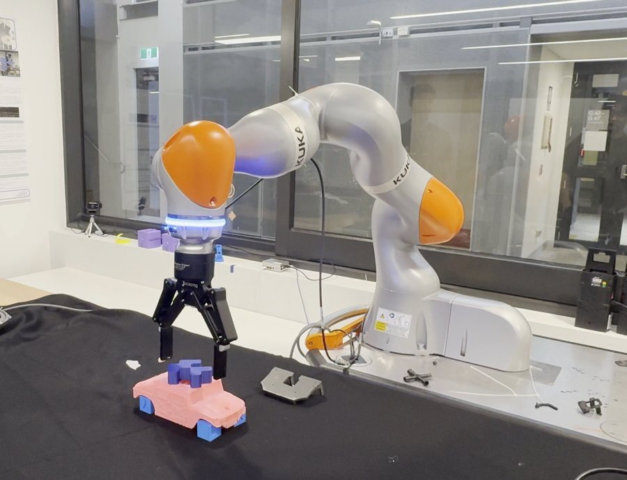 KUKA LBR iiwa arm approaching a model car with its gripper during the lab run.